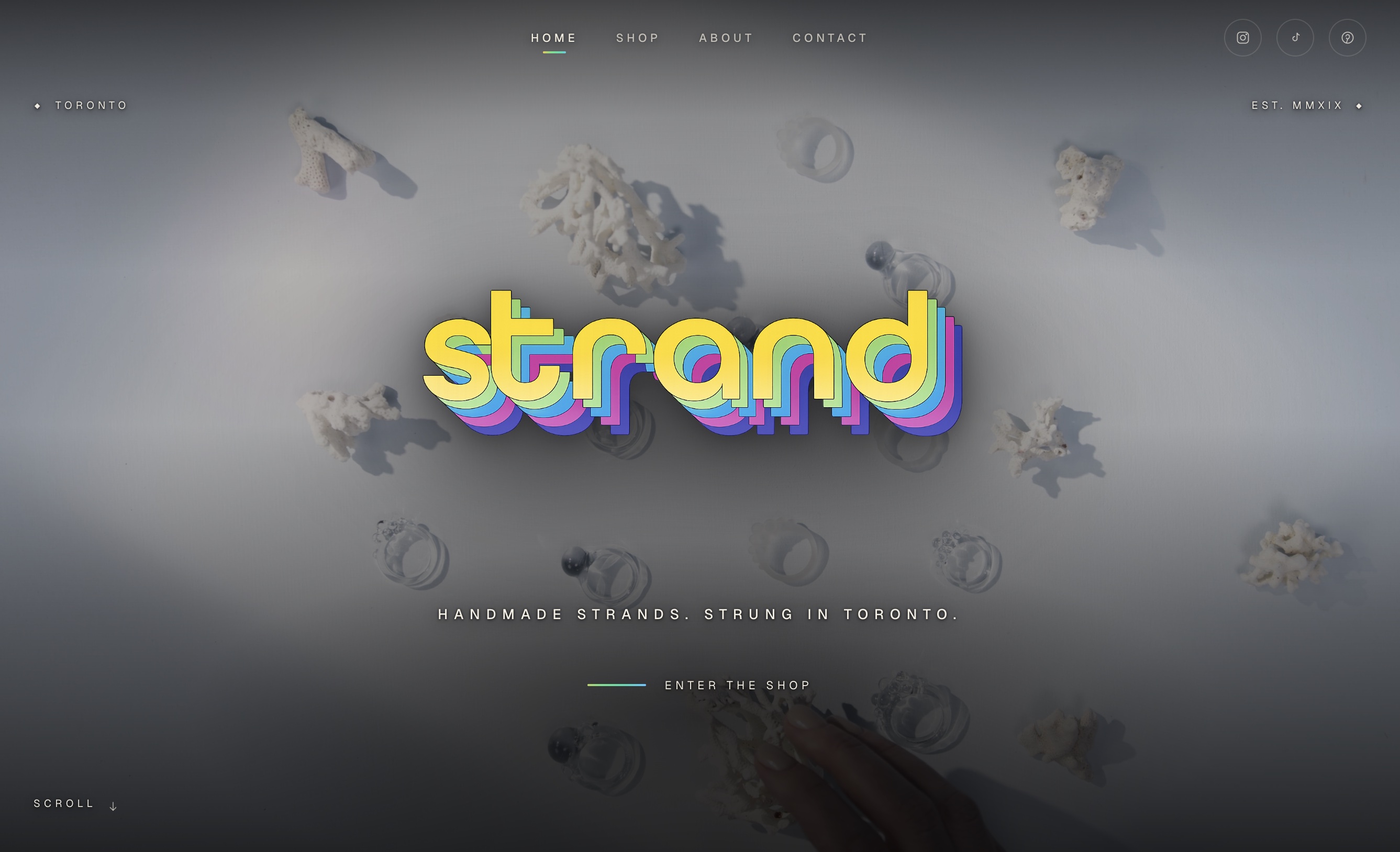 Strand fine jewelry e-commerce homepage — product grid with serif headline and editorial spacing